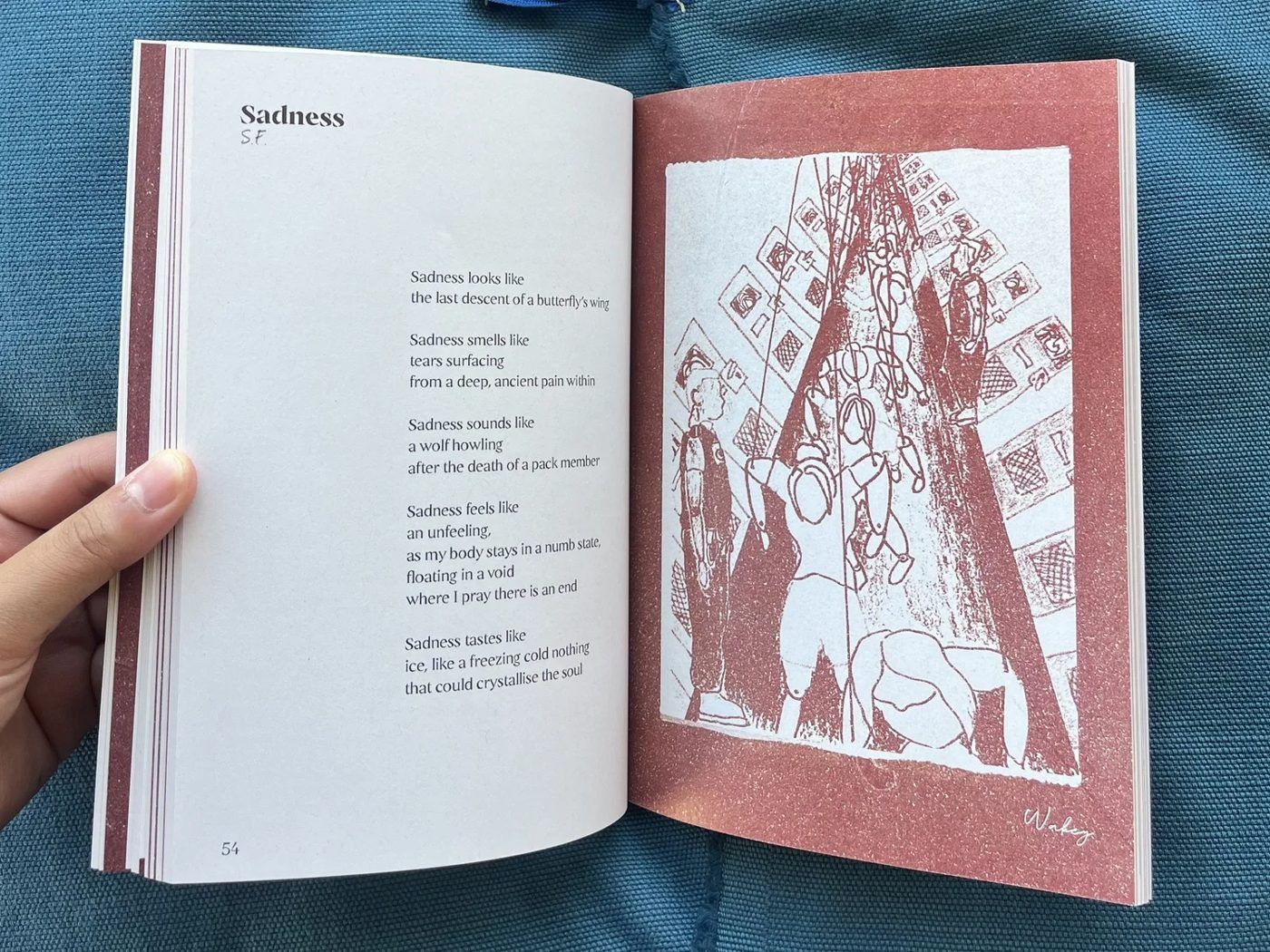An open copy of Wāhine Inside, held in hand.